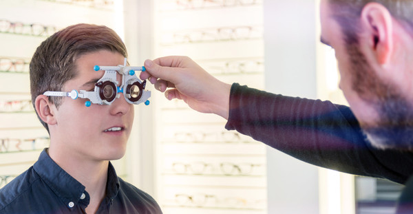 Optiker beim einstellen einer Testbrille an Kunden